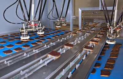 Two Venturi-based end effectors per robot gently pick the rusk slices and place them into the infeed chain of the tray loader.
