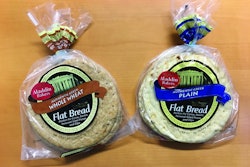 The robot picks and places flat pita from a conveyor into stacks for bagging.