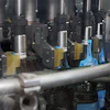 Close-up of the Innoket Neo labeler shows the shoulder-label seal being applied to the bottles.