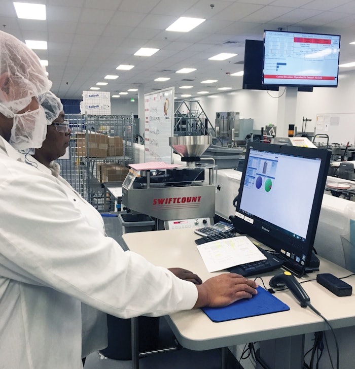 Sovensky Preston (front) and Janice Jackson (rear) analyze OEE data on Packaging Line 2 at Pharmavite in Opelika, Alabama.