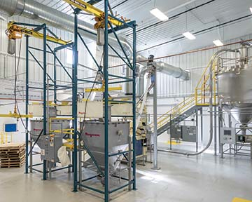 Side-by-side beam-and-hoist-style bulk bag dischargers allow for one frame to discharge peanuts while the other is reloaded. Photo courtesy of Flexicon Corporation.