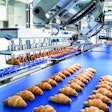 A two-axis robot gently picks filled croissants from the transport module and places them back onto a conveyor.