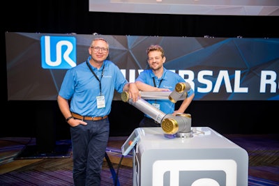 At left, Universal Robots President Jürgen von Hollen stands with the Golden Edition Cobot.