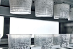 The denester puts in-mold-labeled soup cups onto the walking beam infeed conveyor.