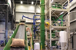 Burlap sacks travel to the automatic bag slitting machine, which places green coffee beans in the hopper and then disposes the sack. This limits handling of the product, reducing worker and food safety risks. Photo by Brian Hippensteel/Brand Neue.