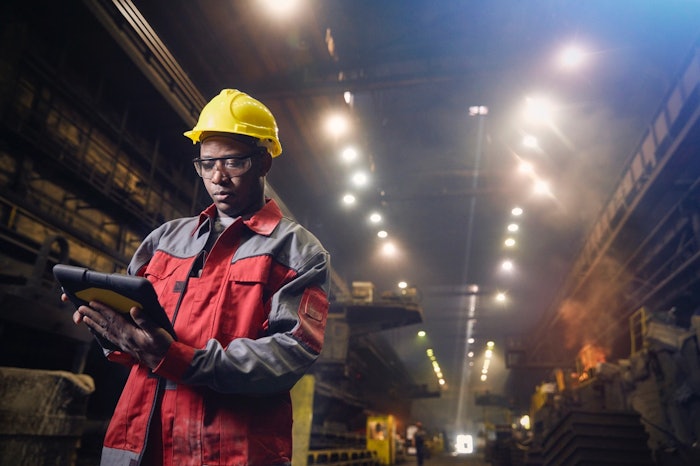 Industrial worker uses tablet to access data wirelessly.