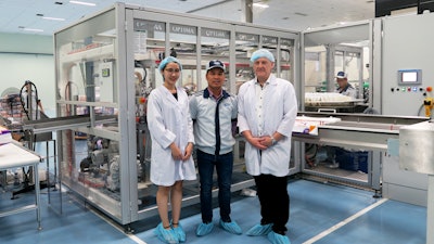 Factory Manager Nguyen Duc Vinh (middle) shows Andreas Rothbauer (right) the OPTIMA DS1 in production.