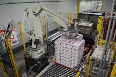 The robot picks two rows of six 4-lb bags from a conveyor and transfers them to the display.