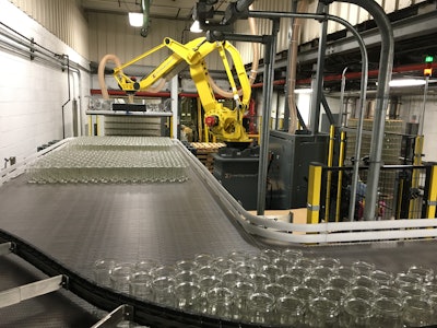 At a speed of 2.5 layers/min, the robot picks a full layer of jars from a pallet and places it on the filling line infeed.