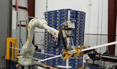 A six-axis articulated robot applies corner boards to the four edges of the pallet, after which it is stretch wrapped.
