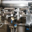 Pre-labeled pouches, seen here from their transparent backs, are being opened and filled in the GP-M3000 before being vibrated to settle the buds, then heat-sealed.