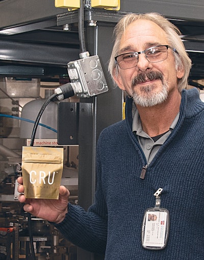 Dennis Schum, Harvest House's engineer, with a sealed branded pouch of buds.