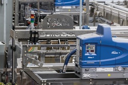 Near the end of the new canning line sits a tray packer that receives six-count cartons from an upstream cartoner and packs them into corrugated trays four per tray.