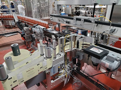 The front-and-back pressure-sensitive labeler features two digitally controlled stepper drive label applicators and synchronous overhead bottle hold down.