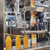 The shrink-sleeve labeler features servo drive technology and applies either a full-body or a neck label (shown left).