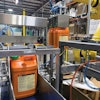 The robot picks two containers at a time and places them gently into the corrugated reshippers.