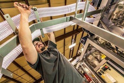 Scott Pitchford, a mechanical assembly technician, works on the vacuum collator system for a cartoner.