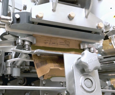 Filled packages eventually move through this heat-sealing station and then a cooling station before dropping onto a discharge chute.