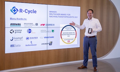 Dr. Benedikt Brenken, Director of the R-Cycle Initiative, accepts the award on behalf of the consortium.