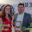 Emma Cole, a member of the Batavia Environmental Commission, presents Green Ole Award to Hector Leon, director of operations for GreenSeed Contract Packaging.