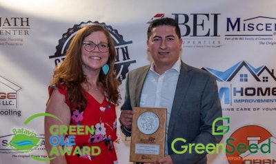 Emma Cole, a member of the Batavia Environmental Commission, presents Green Ole Award to Hector Leon, director of operations for GreenSeed Contract Packaging.