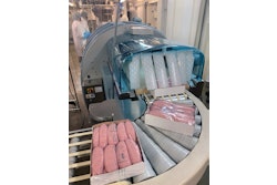 Freshly wrapped paperboard trays of fresh sausages emerge from the cling film application system.