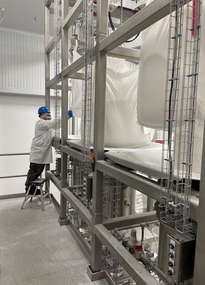 Tote bags of powder ingredients are hoisted into the bulk bag discharger stations.