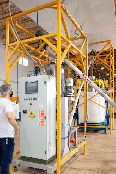 The flexible screw conveyor (top front) transfers beans to the grinder, from which a second flexible screw conveyor moves ground coffee to the bulk bag filler (rear).