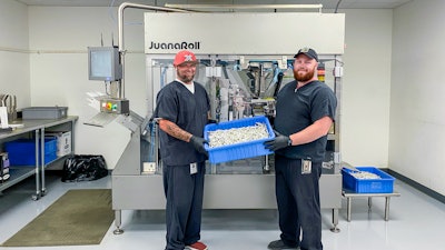 John Lamm, Juana Roll Technician Lead (left), and Elijah Streadwick, Assistant Manager (right), both of NGW, with product in front of the JuanaRoll eight-channel automatic pre-roll machine, available in models with from one to eight channels.