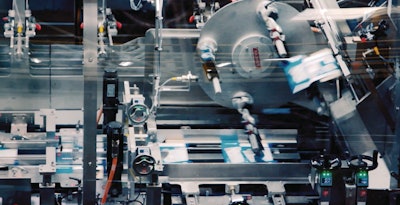 Printed paperboard cartons are opened from magazines of 2D blanks by way of mechanical gripers, plus an “elegant” air-assist carton opening feature to ensure the cartons fully open.