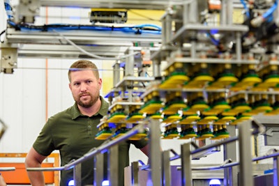 Jordan Hamrick, President, next to a custom dual-robot case packer.