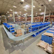 The updated layout in this fulfillment center keeps gravity fed cases moving smoothly through picking station, around elbows, and down to taping and palletizing.