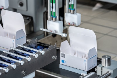 A robot picks up one pipette for each carton of vials.