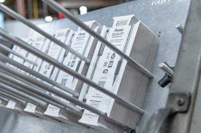 A flat paperboard blank is picked from a magazine and formed into a blister on the equipment.