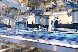 Collating F4 SCARA robots near the end of the infeed belt pick product as it travels to the right. Note the amount of product has dwindled compared to the 34 x 4 format at the start of the infeed. Groups of three sticks are collated on the narrower belts that travel to the left. Finally, cartons that have been filled and lidded upstream travel to the right, and out of the system.