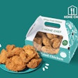 The new packaging for Home Chef’s Fried Chicken consists of a paper gable box with handles that features venting holes that allow condensation to escape the packaging and a window through which consumers can see the product.