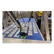 The Delta Robot picks pouches off a conveyor, then orients and places them into a tray pattern on a mass conveyor that feeds the tray-loading robot.