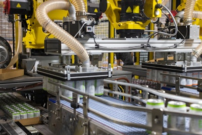 A four-axis robot with two end effectors picks up 48 cans, with each vacuum head picking up 24 cans, each head handling a different variety, and placing them on a conveyor leading to the cartoner.
