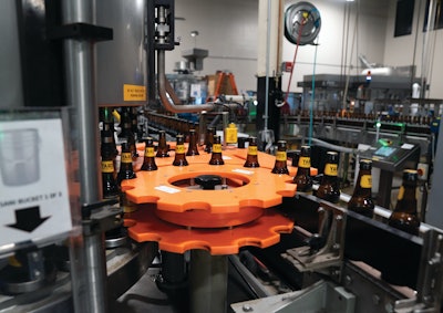 Naked bottles enter the labeler, and leave via starwheel adorned with cold glue-attached neck and body labels.