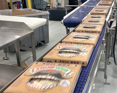 A blur of packaged Screamin’ Sicilian pizzas fly off the line on their way to case packing and temperature-controlled distribution to customers.