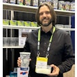 Churchill Container’s Erik Johnson holds one of the cups made from 50% recycled content from PP purification along with a container of PureFive resin.