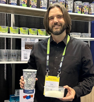 Churchill Container’s Erik Johnson holds one of the cups made from 50% recycled content from PP purification along with a container of PureFive resin.