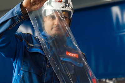 Dr. Vinay Kumar, senior scientist and project manager at VTT, examines cellulose-based transparent film produced at VTT’s CelluloseFilm pilot line.