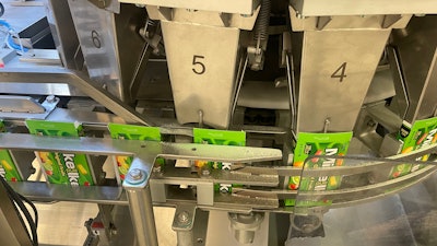 Folding cartons receive candy from one of 18 cups on a volumetric filler running at about 450 cartons/min.