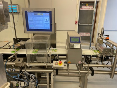 Filled cartons run through this combination checkweigher and metal detector , which also communicates with the volumetric filler’s controller to improve filling accuracy.