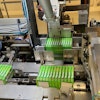 Shown here in the tray packer are one 12-count group of cartons in the flap compression station, another in the tray load station, and a third that is about to be pushed into the tray load station.