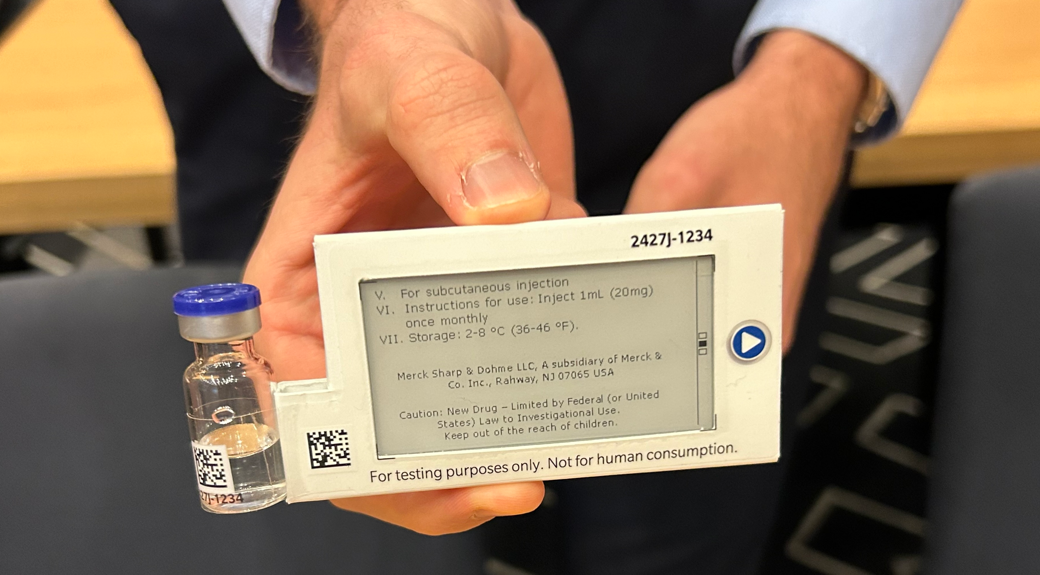 A prototype of a digital display label attached to a vial containing a drug for a clinical trial.