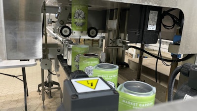 Shrink sleeves being 'shot' onto awaiting bright cans, pictured here traveling into the steam tunnel.