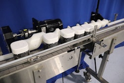 A timing screw squares Olly containers over the date coder before releasing them down the conveyor 8.25 inches apart.