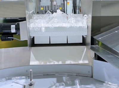 The PET containers are fed into the line by this versatile unscrambler.